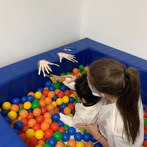 Niño en la piscina de bolas durante una sesión de estimulación sensorial
