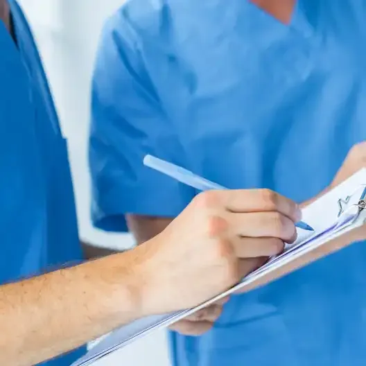 Profesional sanitario tomando notas en un informe
